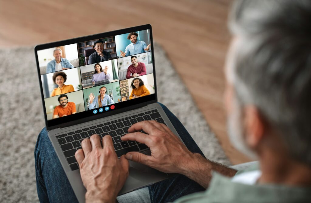 Mature Man Participating in Virtual Meeting on Laptop at Home