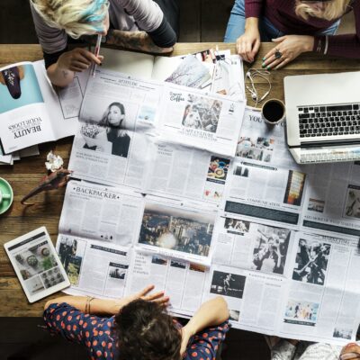 Colleagues discussing newspaper articles